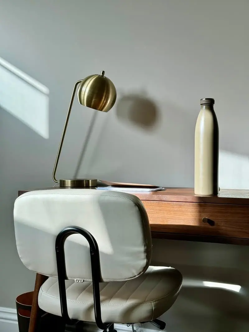 A desk with a paper notebook and a stainless steel water bottle